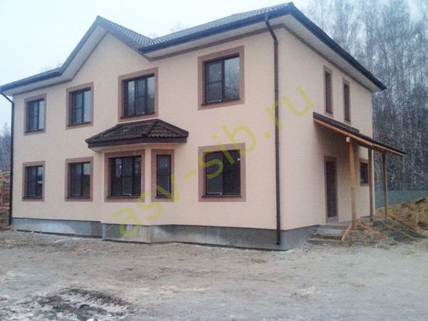 Большой кирпичный коттедж в два этажа с чердачной крышей.